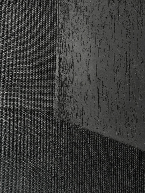 Macro detail of two adjoining textures on the panel surface: a woven canvas-like grid beside a vertically ridged texture.