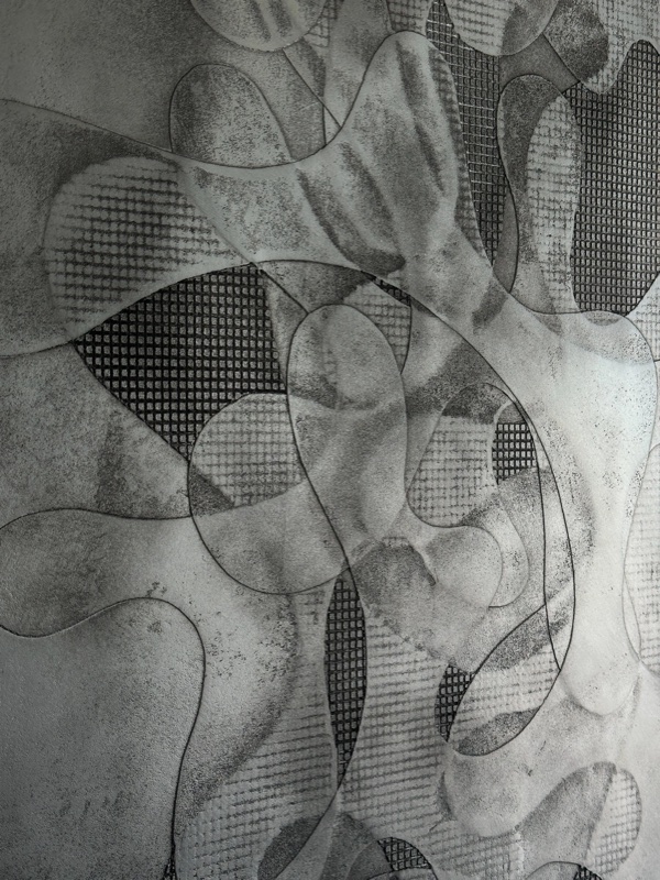 Tight macro crop of carved organic lines and mesh-textured recessed sections.