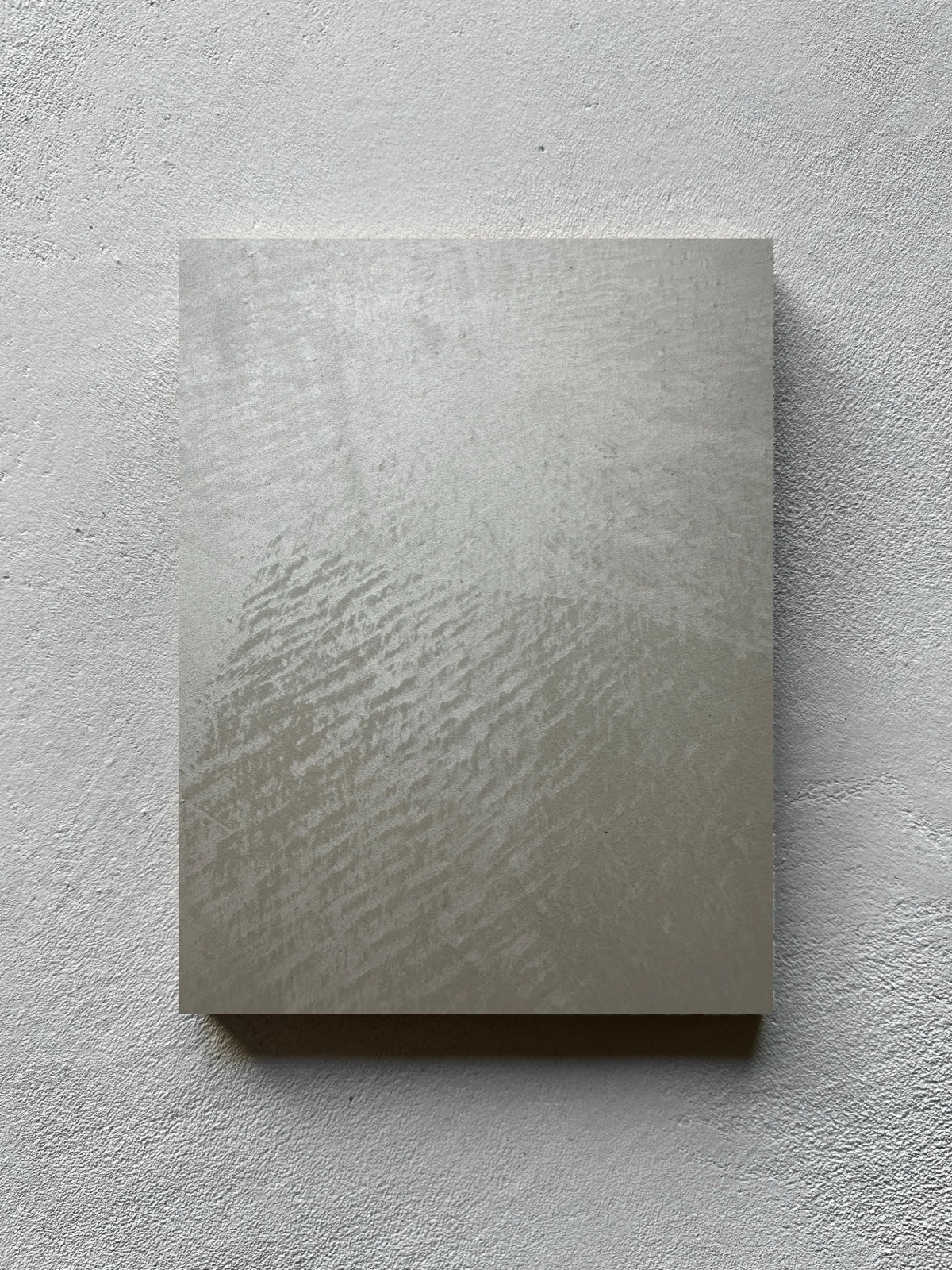 Brushed pearlescent plaster catching light on the diagonal.