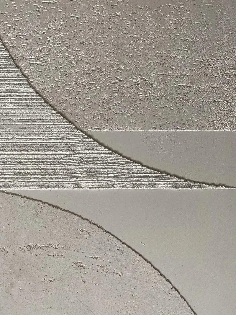 Full-height plaster wall detail in the Mazama cabin, raking mountain light