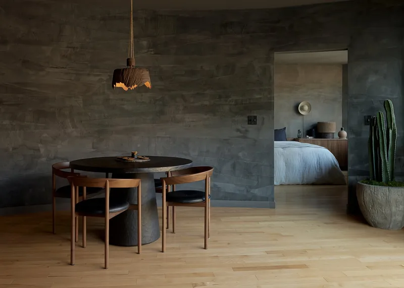 Living and dining area with hand-troweled plaster walls, the bedroom beyond, Tremont residence